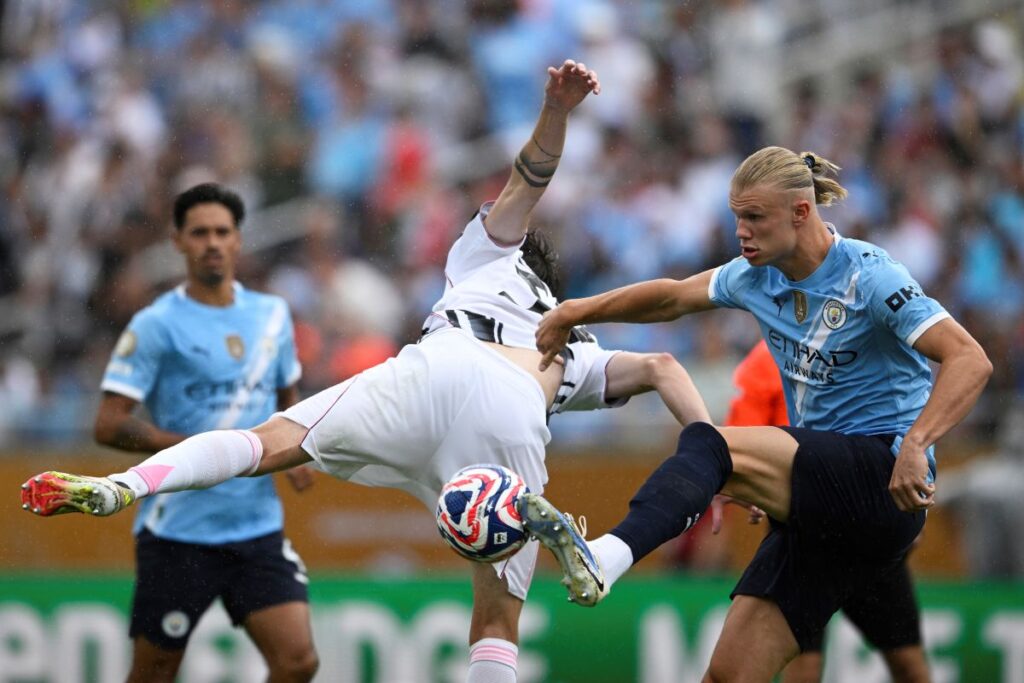 Manchester City's Erling Haaland, right, and Juventus' Nicolo Savona battle for the ball during the Club World Cup Group G soccer match between Juventus and Manchester City in Orlando, Fla., Thursday, June 26, 2025. (AP Photo/Phelan Ebenhack)
