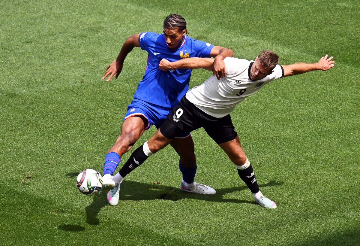 Germany's Niclas Fuellkrug, right, and France's Loic Bade, left, challenge for the ball during the Nations League third place soccer match between Germany and France in Stuttgart, Germany, Sunday, June 8, 2025. (Marijan Murat/dpa via AP)