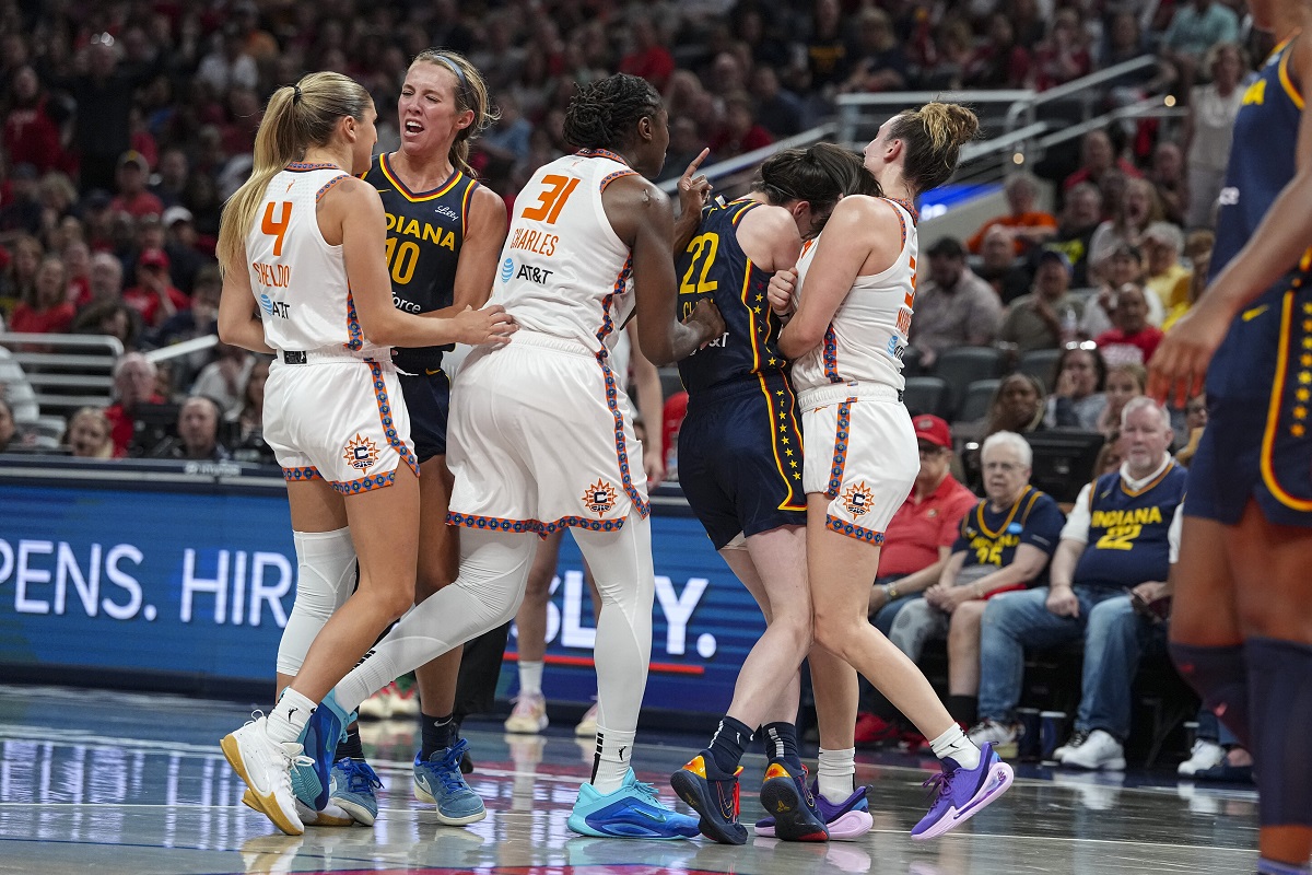 Indiana Fever guard Caitlin Clark (22) is hit by Connecticut Sun guard Marina Mabrey (3) during a scuffle in the second half of a WNBA basketball game in Indianapolis, Tuesday, June 17, 2025. (AP Photo/Michael Conroy)