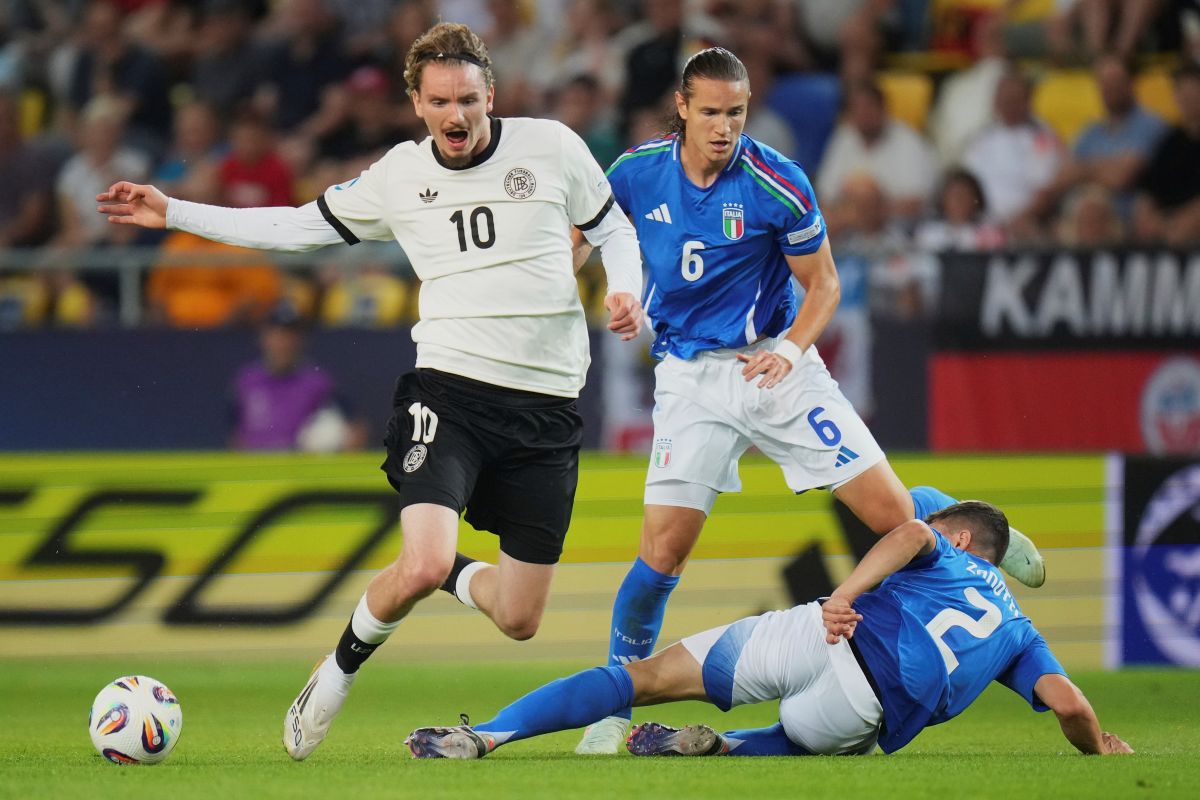 Germany's Nick Woltemade, left, duels for the ball with Italy's Daniele Ghilardi, top right, and Italy's Mattia Zanotti during a quarter final soccer match between Germany and Italy at the European U-21 Championship at the DAC Arena in Dunajska Streda, Slovakia, Sunday, June 22, 2025. (AP Photo/Petr David Josek)