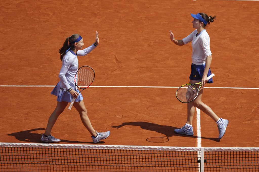 Kazakhstan Anna Danilina, right, and Serbia's Aleksandra Krunic react as they play against Italy's Jasmine Paolini, bottom right, and Sara Errani during their women's doubles final match of the French Tennis Open at the Roland-Garros stadium in Paris, Sunday, June 8, 2025. (AP Photo/Thibault Camus)
