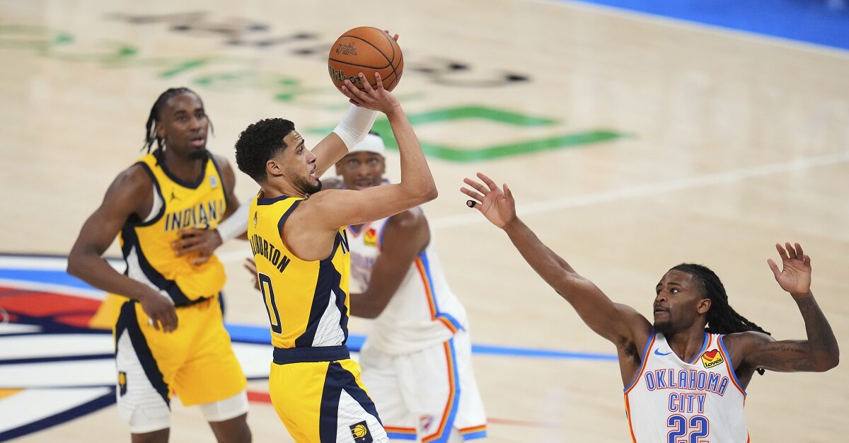 Indiana Pacers guard Tyrese Haliburton (0) shoots a 3-pointer against Oklahoma City Thunder guard Cason Wallace (22) during the second half of Game 1 of the NBA Finals basketball series Thursday, June 5, 2025, in Oklahoma City. (AP Photo/Julio Cortez)