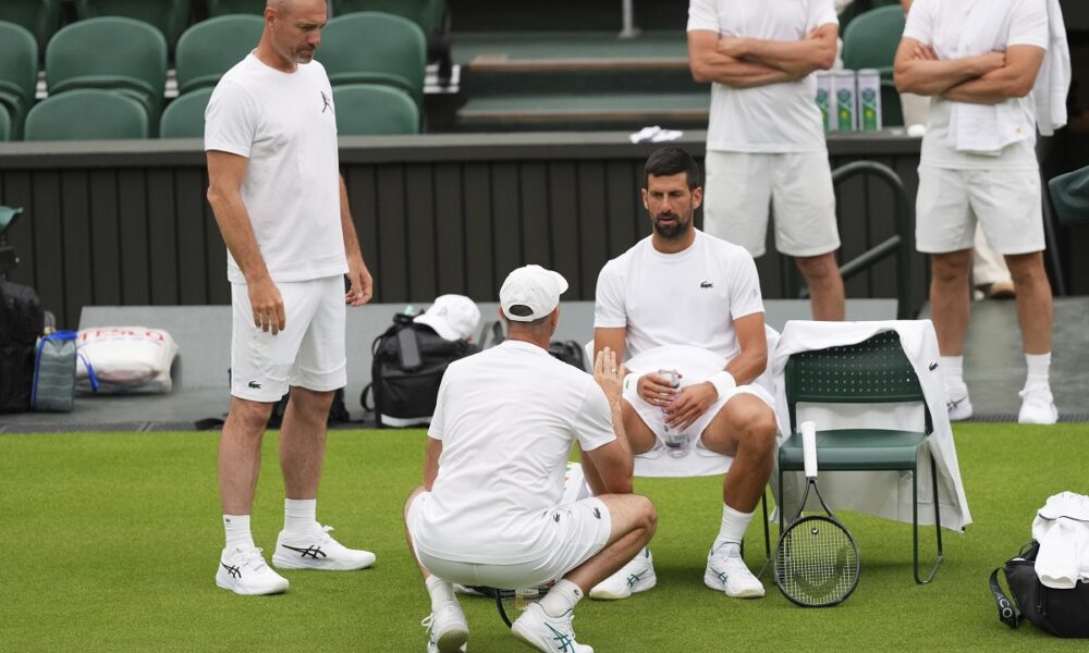 Novak Djokovic of Serbia speaks to a coach during a practice session at the All England Lawn Tennis and Croquet Club, ahead of the Wimbledon Championships in London, Thursday, June 26, 2025. (AP Photo/Kirsty Wigglesworth)