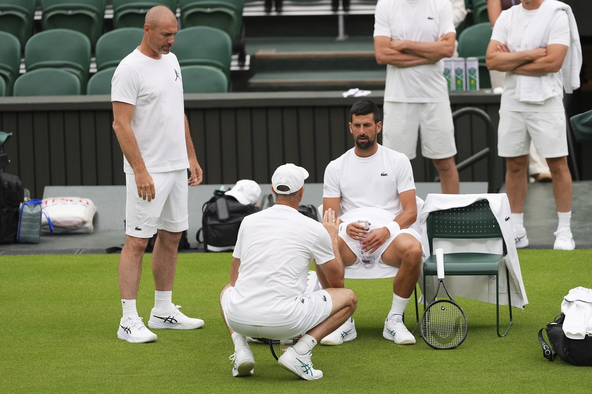 Novak Djokovic of Serbia speaks to a coach during a practice session at the All England Lawn Tennis and Croquet Club, ahead of the Wimbledon Championships in London, Thursday, June 26, 2025. (AP Photo/Kirsty Wigglesworth)