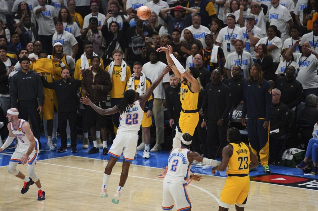 Indiana Pacers guard Tyrese Haliburton (0) shoots a 3-pointer against Oklahoma City Thunder guard Cason Wallace (22) during the second half of Game 1 of the NBA Finals basketball series Thursday, June 5, 2025, in Oklahoma City. (AP Photo/Nate Billings)