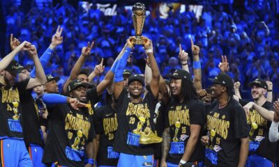Oklahoma City Thunder guard Shai Gilgeous-Alexander, center, holds up the MVP trophy as he celebrates with his team after they won the NBA basketball championship with a Game 7 victory against the Indiana Pacers Sunday, June 22, 2025, in Oklahoma City. (AP Photo/Julio Cortez)