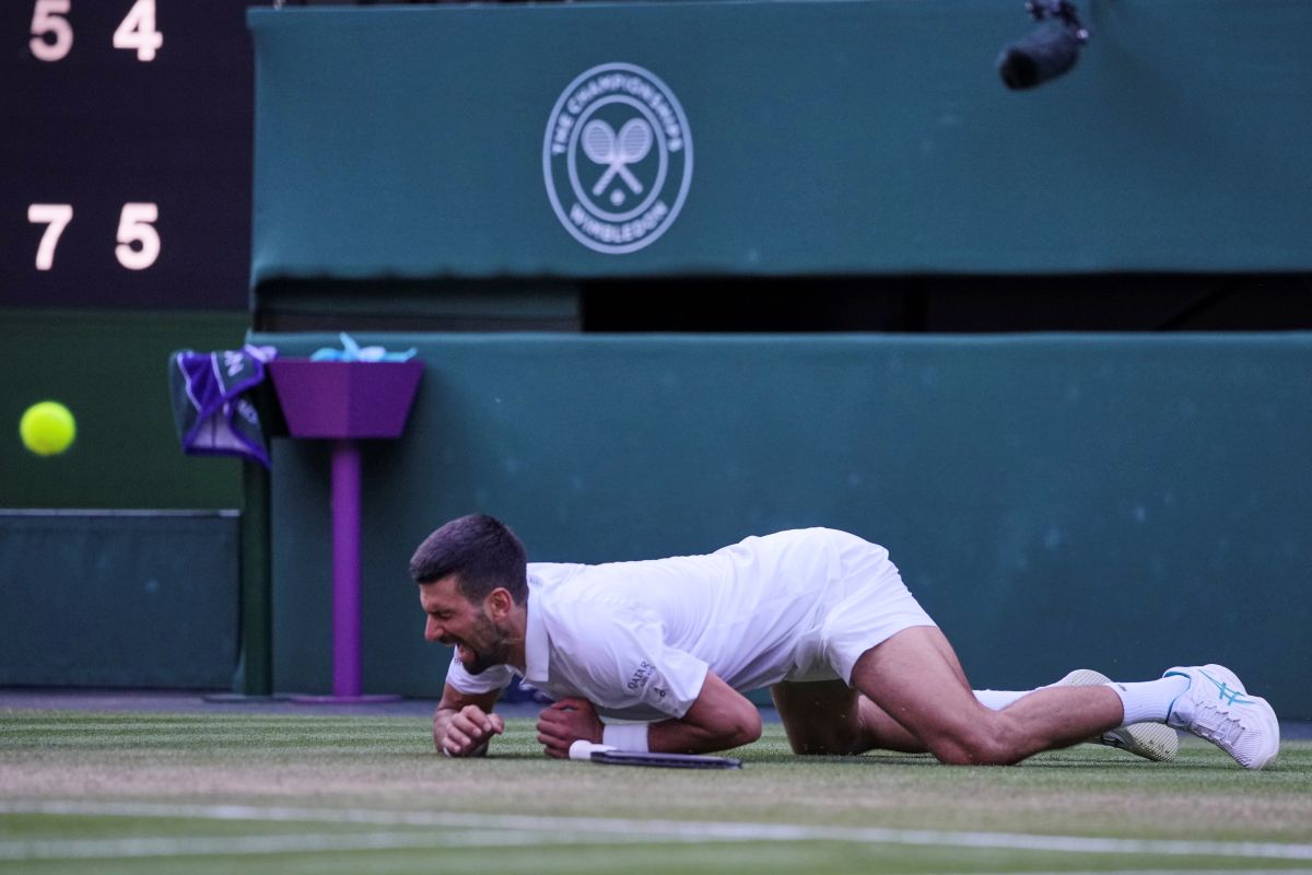 Serbia's Novak Djokovic reacts after slipping and falling when attempting a return to Italy's Flavio Cobolli during a quarterfinal men's singles match at the Wimbledon Tennis Championships in London, Wednesday, July 9, 2025. (AP Photo/Kin Cheung)