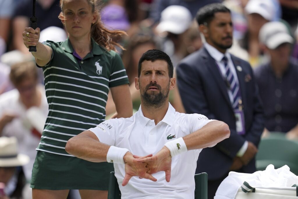 Serbia's Novak Djokovic stretches during a changes of ends break as he plays Australia's Alex de Minaur during a fourth round men's singles match at the Wimbledon Tennis Championships in London, Monday, July 7, 2025. (AP Photo/Kin Cheung)
