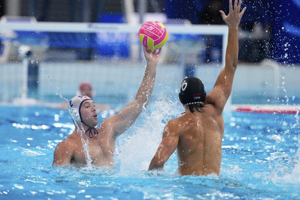 Serbia's Dusan Mandic, left, attempts to score against Hungary's Vendel Csaba Vigvari during a men's water polo semifinal match between Serbia and Hungary at the World Aquatics Championships in Singapore, Tuesday, July 22, 2025. (AP Photo/Vincent Thian)