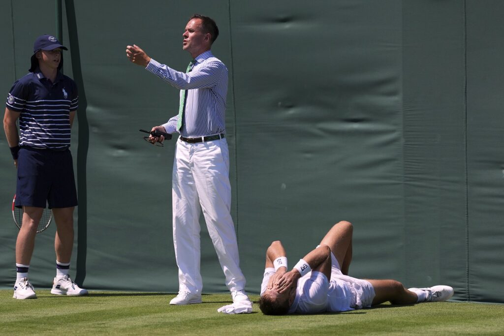 Hamad Medjedovic of Serbia lies injured on the court after he ran into a board during his first round men's singles match against Sebastian Ofner of Austria at the Wimbledon Tennis Championships in London, Tuesday, July 1, 2025.(AP Photo/Dave Shopland)