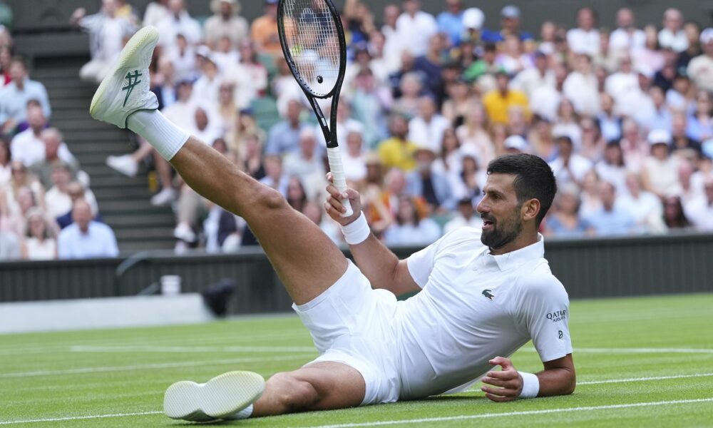 Novak Djokovic of Serbia sits on the grass after diving to return to Miomir Kecmanovic of Serbia during a third round men's singles match at the Wimbledon Tennis Championships in London, Saturday, July 5, 2025. (AP Photo/Kirsty Wigglesworth)