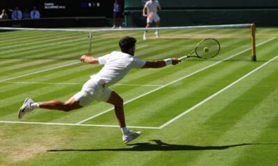 Carlos Alcaraz of Spain returns the ball to Taylor Fritz of the U.S. during the men's semifinal singles match at the Wimbledon Tennis Championships in London, Friday, July 11, 2025.(AP Photo/Kirsty Wigglesworth)