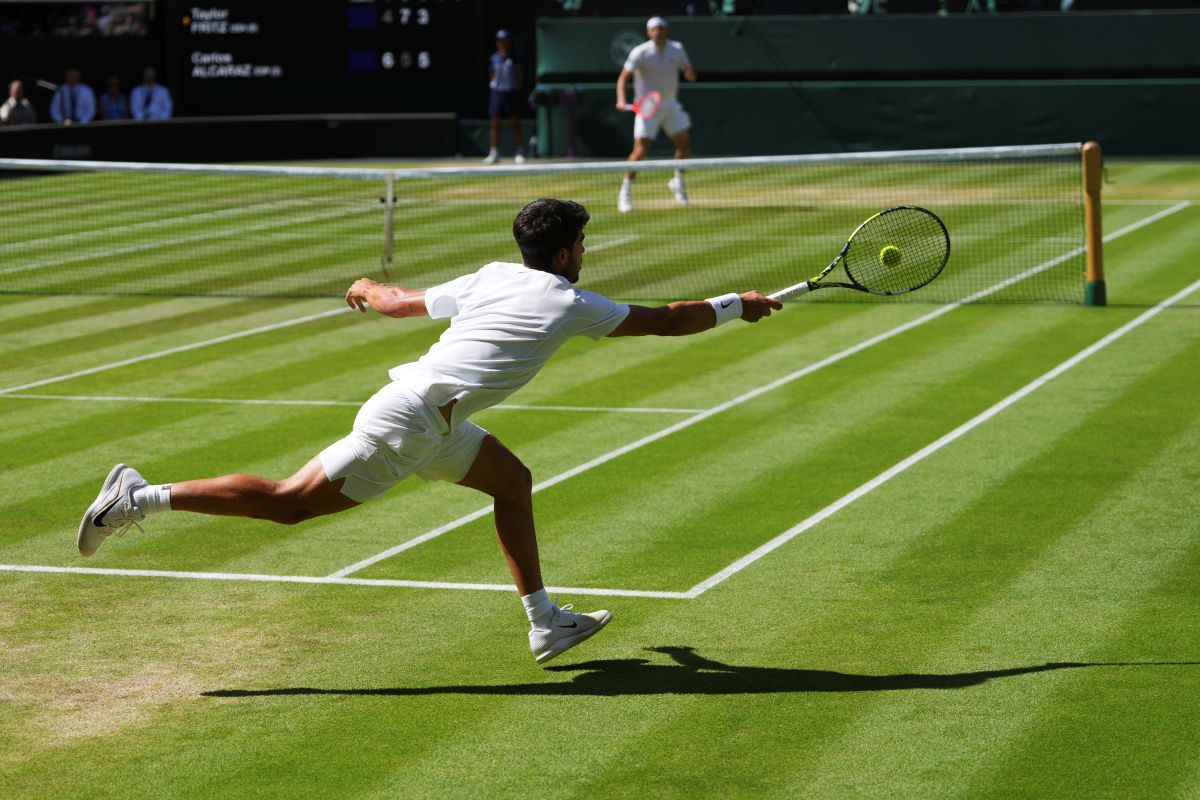 Carlos Alcaraz of Spain returns the ball to Taylor Fritz of the U.S. during the men's semifinal singles match at the Wimbledon Tennis Championships in London, Friday, July 11, 2025.(AP Photo/Kirsty Wigglesworth)