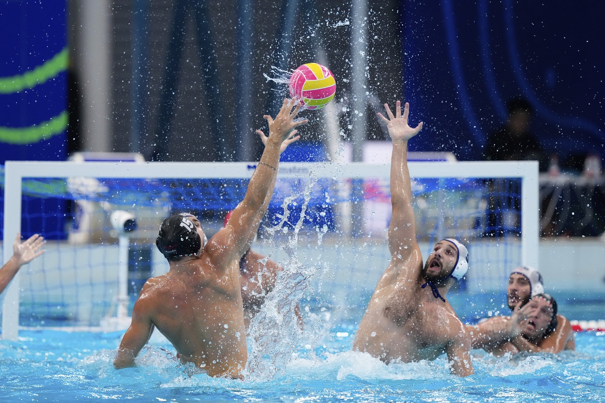 Hungary's Zsombor Vismeg, left, attempts to score against Serbia's Milos Cuk during a men's water polo semifinal match between Serbia and Hungary at the World Aquatics Championships in Singapore, Tuesday, July 22, 2025. (AP Photo/Vincent Thian)
