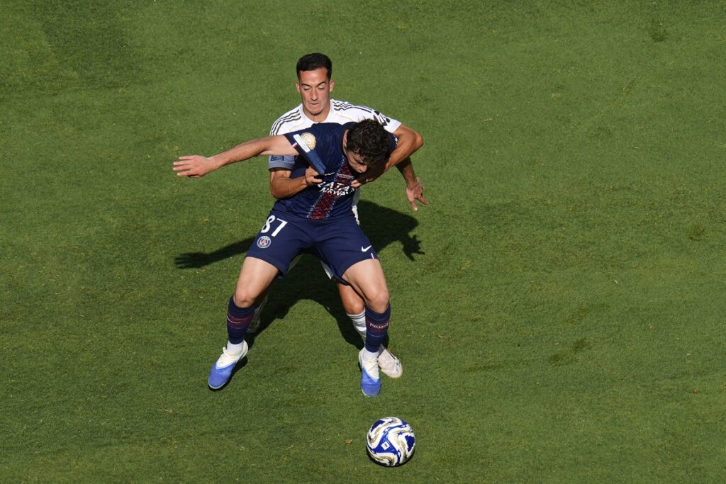 Real Madrid's Lucas Vazquez (17) holds Paris Saint-Germain's Joao Neves (87) as they compete for control of the ball during the Club World Cup semifinal soccer match between PSG and Real Madrid in East Rutherford, N.J., Wednesday, July 9, 2025. (AP Photo/Pamela Smith)