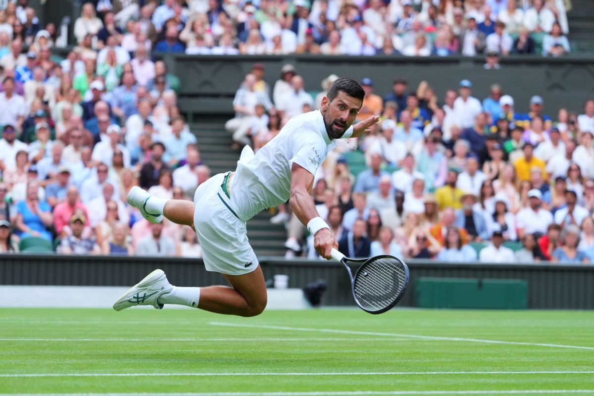 Novak Djokovic of Serbia dives to return to Miomir Kecmanovic of Serbia during a third round men's singles match at the Wimbledon Tennis Championships in London, Saturday, July 5, 2025. (AP Photo/Kirsty Wigglesworth)