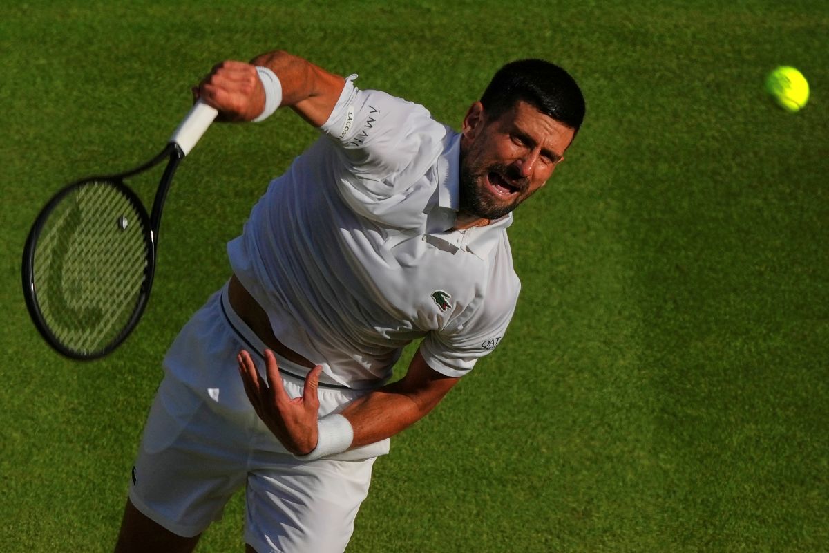 Serbia's Novak Djokovic serves to Italy's Flavio Cobolli during a quarterfinal men's singles match at the Wimbledon Tennis Championships in London, Wednesday, July 9, 2025. (AP Photo/Joanna Chan)