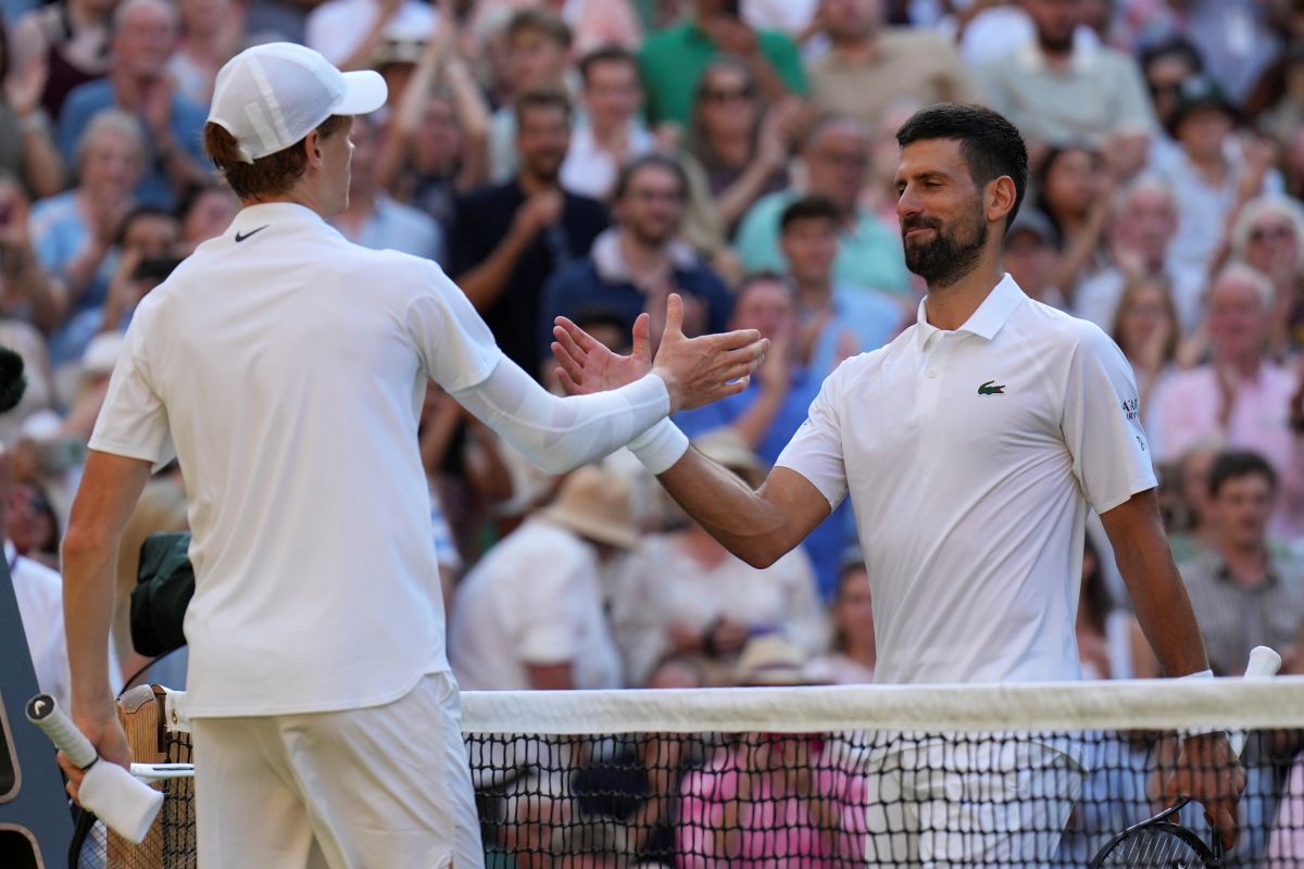 Italy's Jannik Sinner, left, greets Serbia's Novak Djokovic after winning their men's singles semifinal at the Wimbledon Tennis Championships in London, Friday, July 11, 2025. (AP Photo/Kin Cheung)