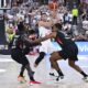 Germanys' Dennis Schröder, left,and Johannes Thiemann, right double team Serbia's Aleksa Avramovic during the final of the Supercup basketball tournament, Saturday, Aug. 16, 2025, in Munich, Germany. (Sven Hoppe/dpa via AP)