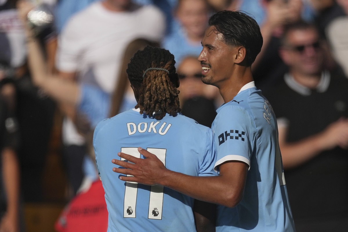 Manchester City's Tijjani Reijnders, right, celebrates with Manchester City's Jeremy Doku after scoring his sides second goal during the English Premier League soccer match between Wolverhampton Wanderers and Manchester City at Molineux Stadium, Wolverhampton, England, Saturday, Aug. 16, 2025. (AP Photo/Dave Shopland)