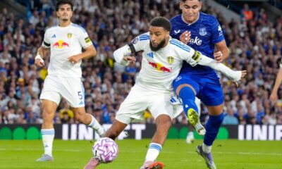 Leeds United's Jayden Bogle, center, and Everton's Carlos Alcaraz, right, battle for the ball during the English Premier League soccer match between Leeds United and Everton at Elland Road, in Leeds, England, Monday, Aug. 18, 2025. (Danny Lawson/PA via AP)